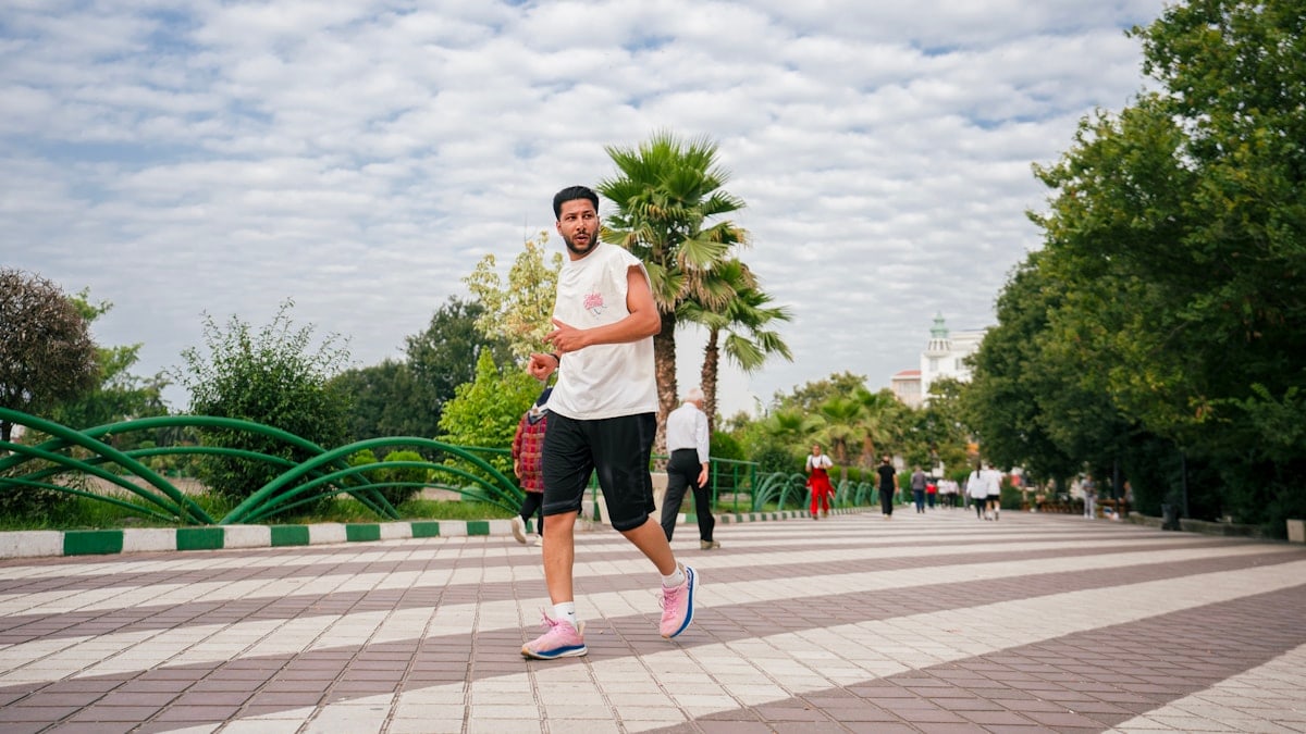 A man is running outdoors in a park.